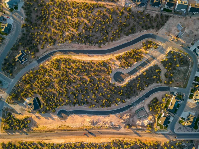 Elevated aerial perspective showcasing a developed residential area with winding paved roads, cul-de-sacs, and established homes