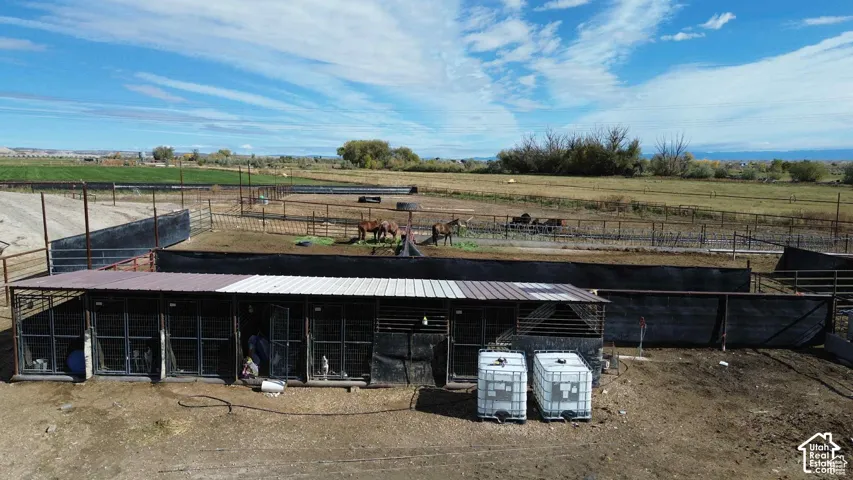 View of front of house with an outbuilding, an exterior structure, a rural view, and a metal roof