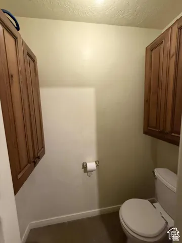 Bathroom featuring baseboards and a textured ceiling
