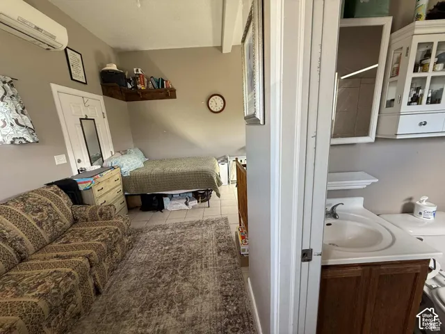Bedroom featuring a wall mounted mini split and light tile patterned floors