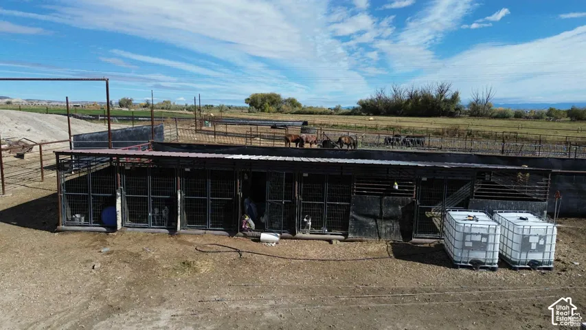 Rear view of house featuring an outbuilding, an exterior structure, and a rural view