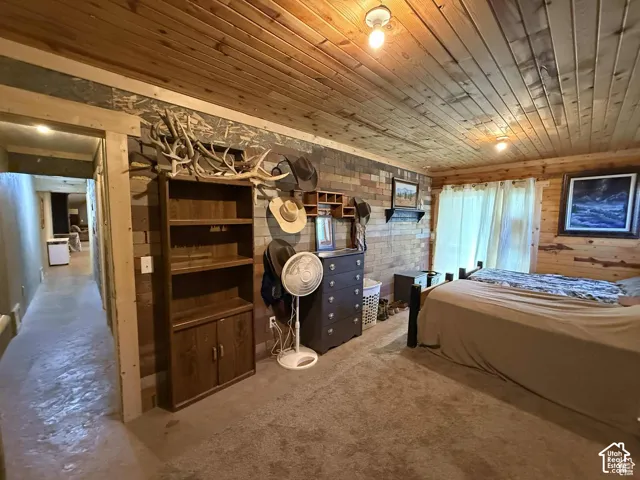 Bedroom featuring wooden ceiling and wooden walls
