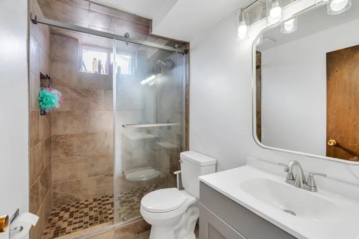 Full bath featuring vanity and a shower stall