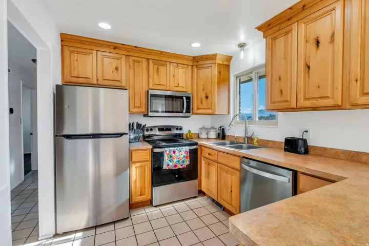 Kitchen featuring stainless steel appliances, light countertops, light tile patterned floors, and recessed lighting