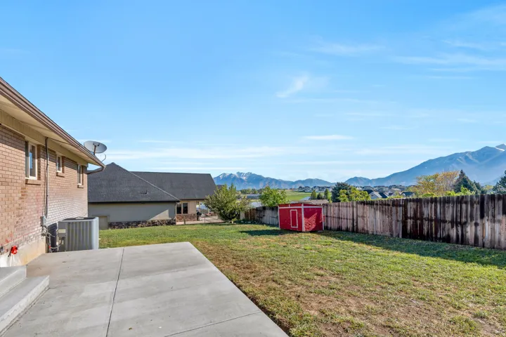 Fenced backyard featuring a storage shed and a mountain view