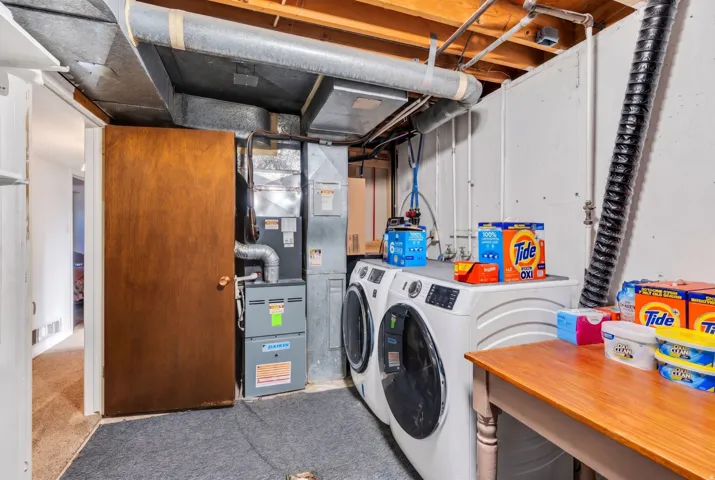 Laundry area with washer and dryer and heating unit