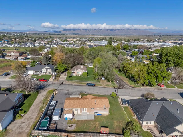 Aerial overview of property's location with nearby suburban area and a mountainous background