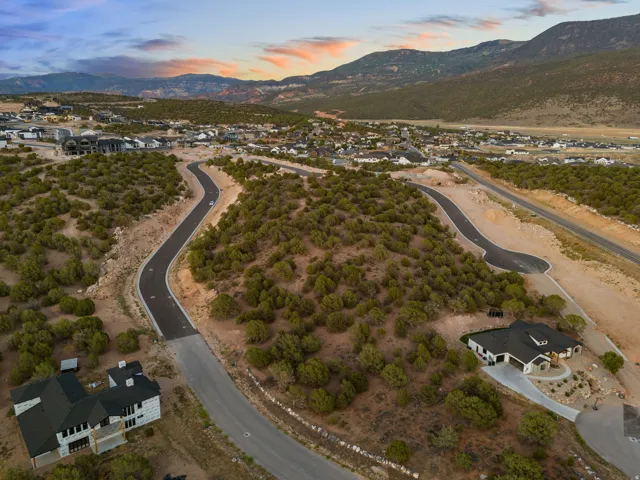 Expansive land parcel featuring new asphalt roads and a natural, undeveloped landscape with scattered shrubbery