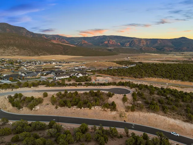 Mountainous landscape featuring a residential community, paved roadways, and natural desert vegetation
