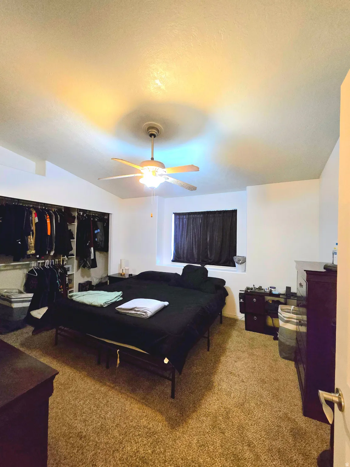 Bedroom with light carpet, vaulted ceiling, and ceiling fan