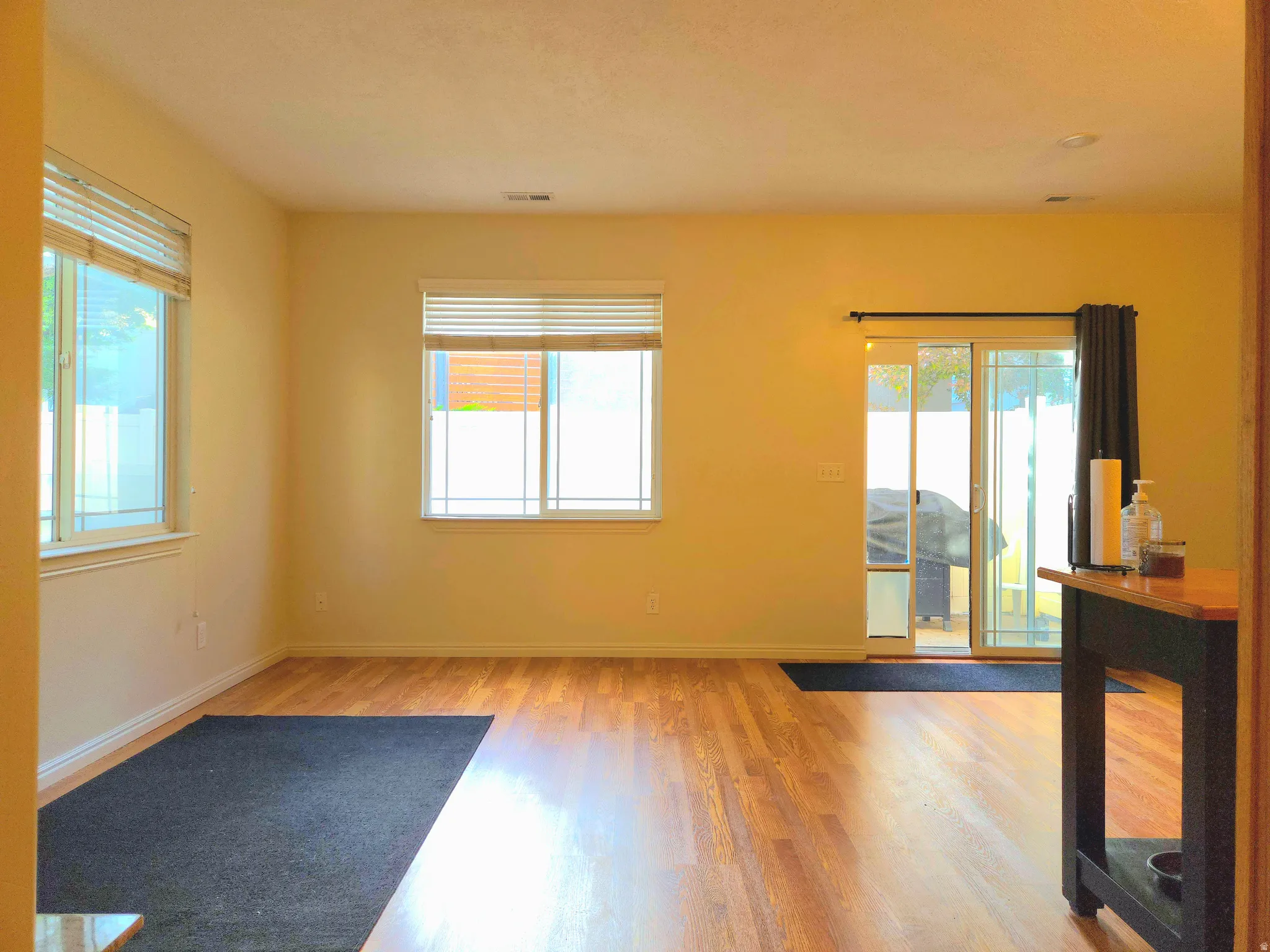 Empty room with light wood finished floors and healthy amount of natural light