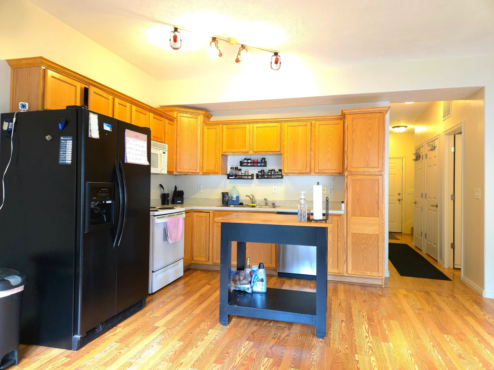 Kitchen with white appliances, light countertops, and light wood finished floors