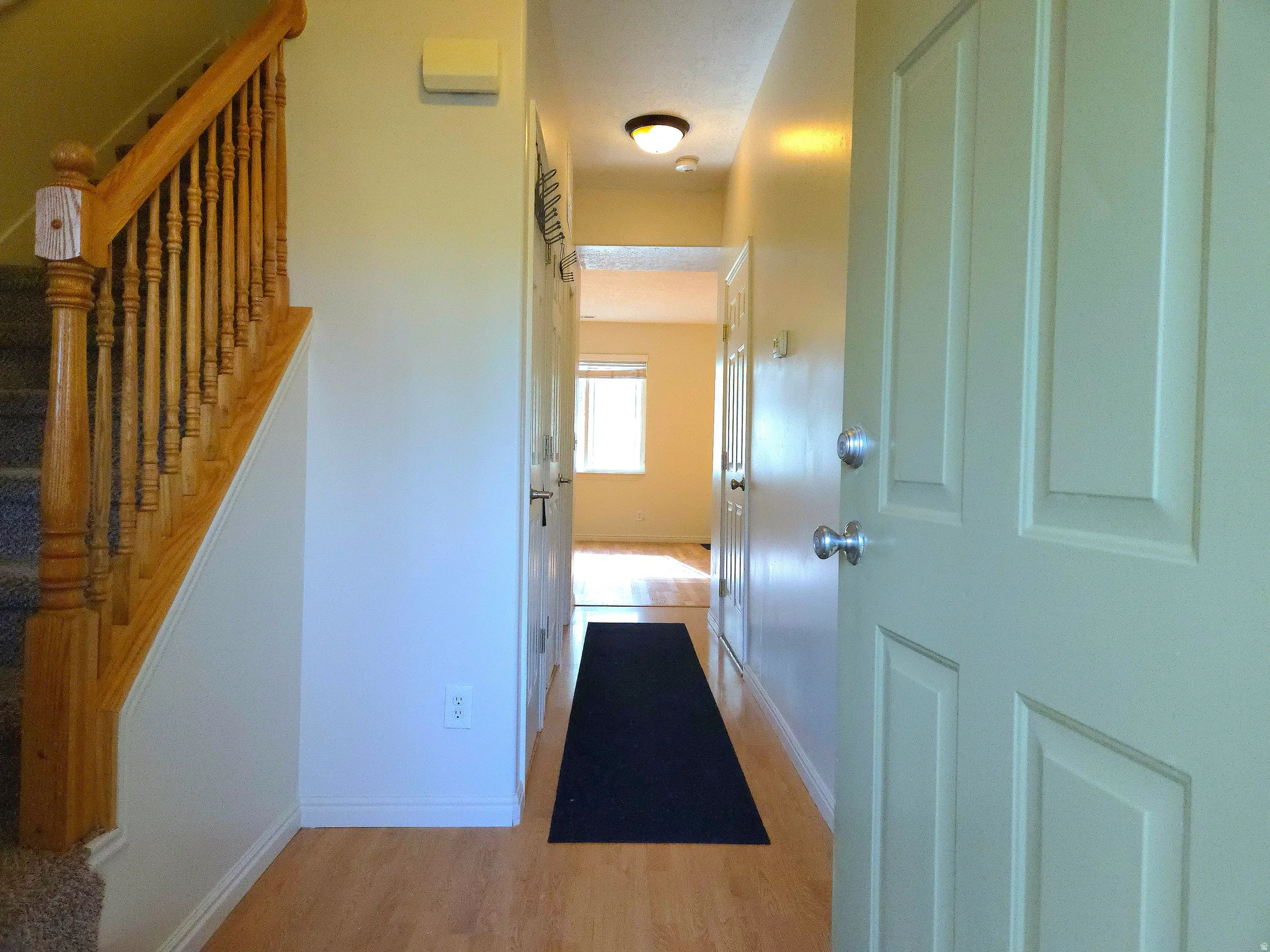 Hallway featuring light wood-style floors and stairs