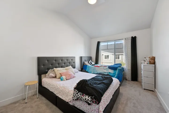 Bedroom with lofted ceiling and light colored carpet