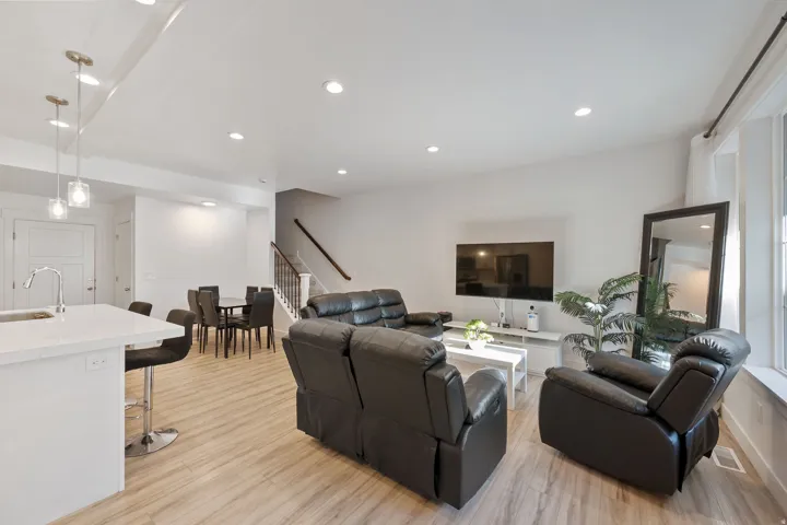 Living area with light wood-type flooring and recessed lighting