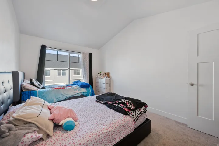 Bedroom with lofted ceiling and light carpet