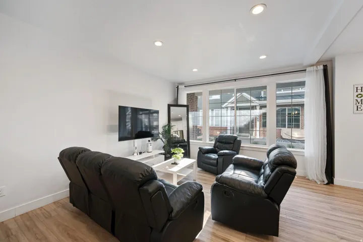 Living room with light wood finished floors and recessed lighting