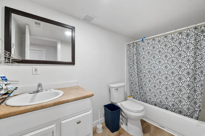 Full bath featuring vanity, shower / bath combo with shower curtain, and light wood-style flooring