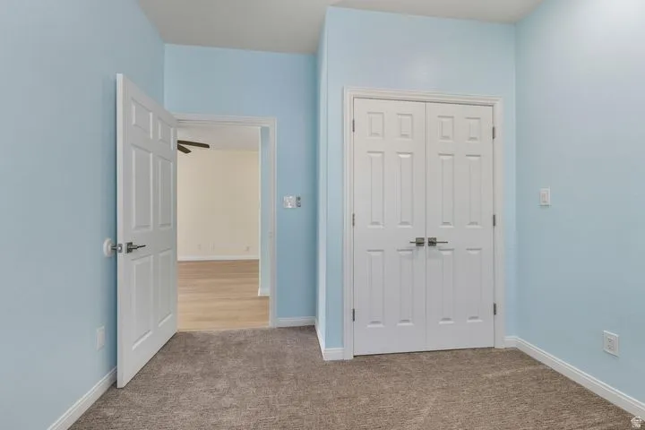 Unfurnished bedroom featuring light colored carpet and a closet