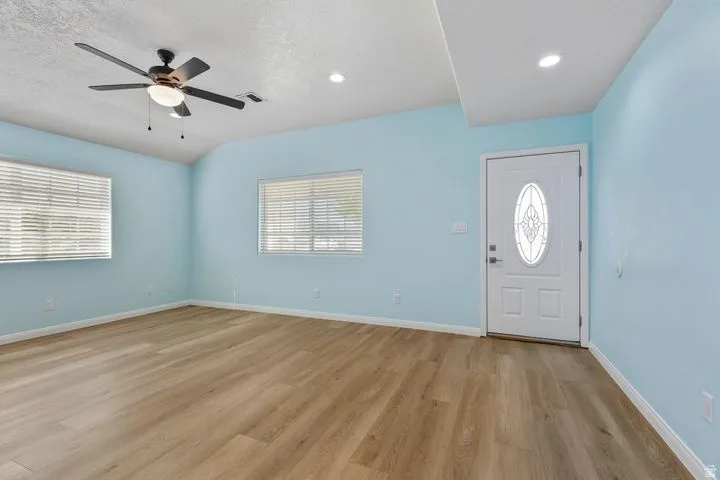 Foyer with ceiling fan, light wood-style floors, plenty of natural light, and a textured ceiling