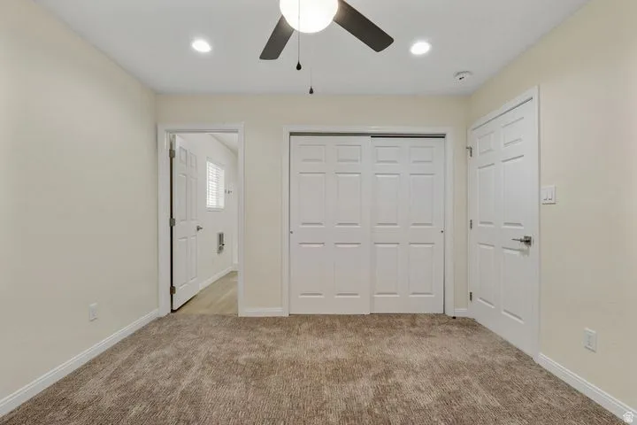 Unfurnished bedroom with light colored carpet, a closet, ceiling fan, and recessed lighting