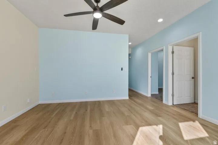 Spare room with light wood-type flooring, ceiling fan, and recessed lighting