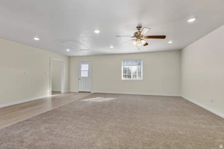 Empty room featuring light carpet, a ceiling fan, and recessed lighting