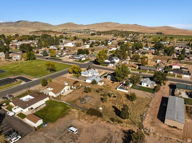 Aerial view of property's location featuring a mountain backdrop and nearby suburban area