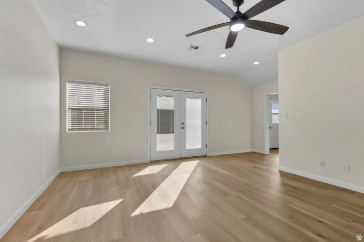 Spare room featuring french doors, light wood-style flooring, recessed lighting, plenty of natural light, and a ceiling fan