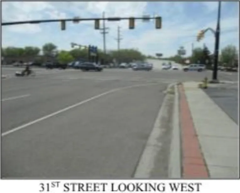 View of asphalt road with traffic lights and sidewalks