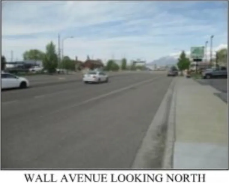 View of asphalt street featuring street lighting and sidewalks