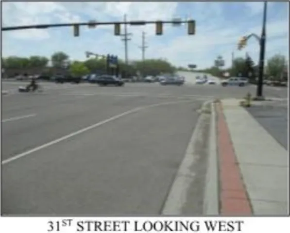 View of asphalt road with traffic lights and sidewalks