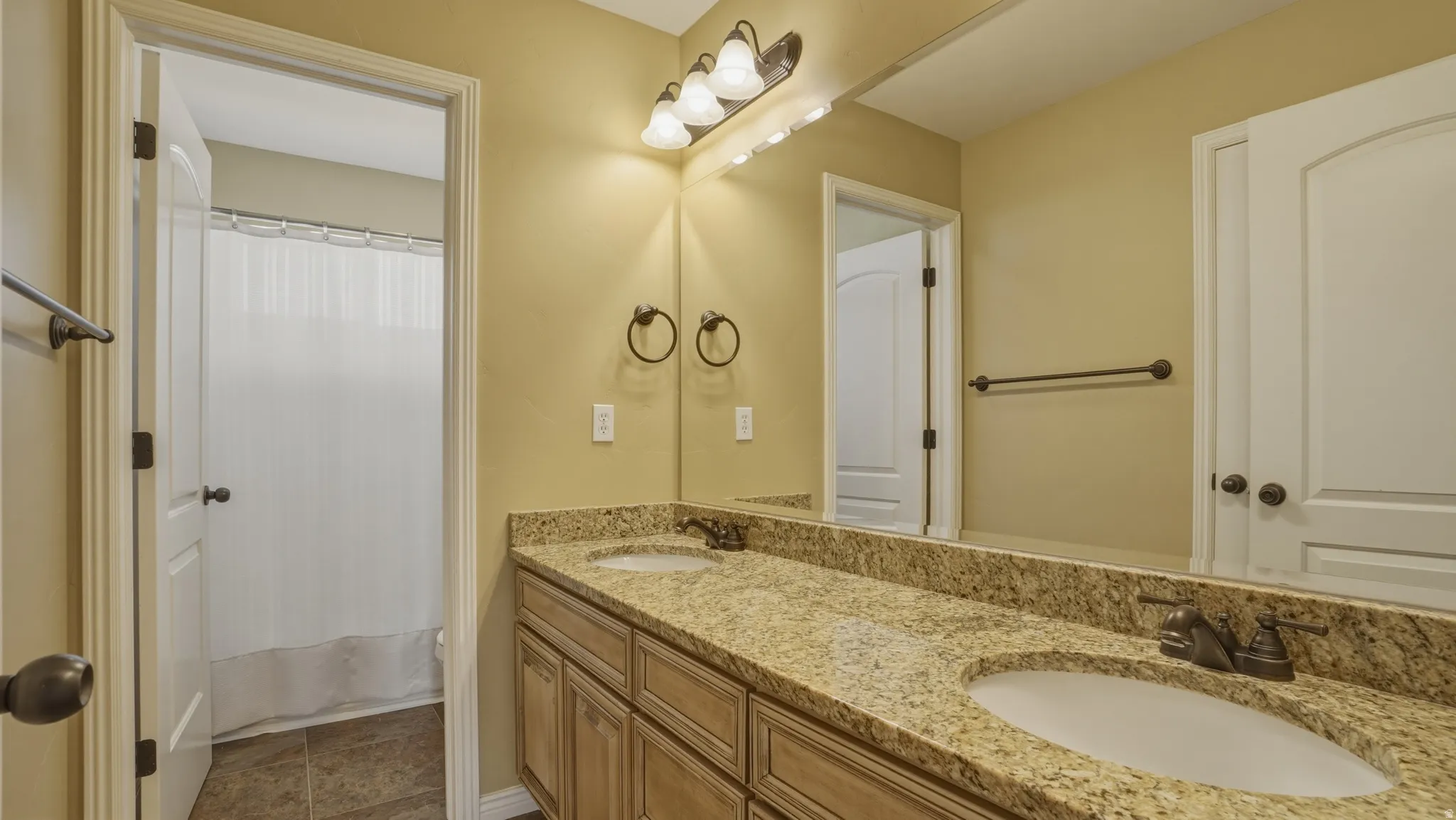 Bathroom with double vanity and shower / bath combo