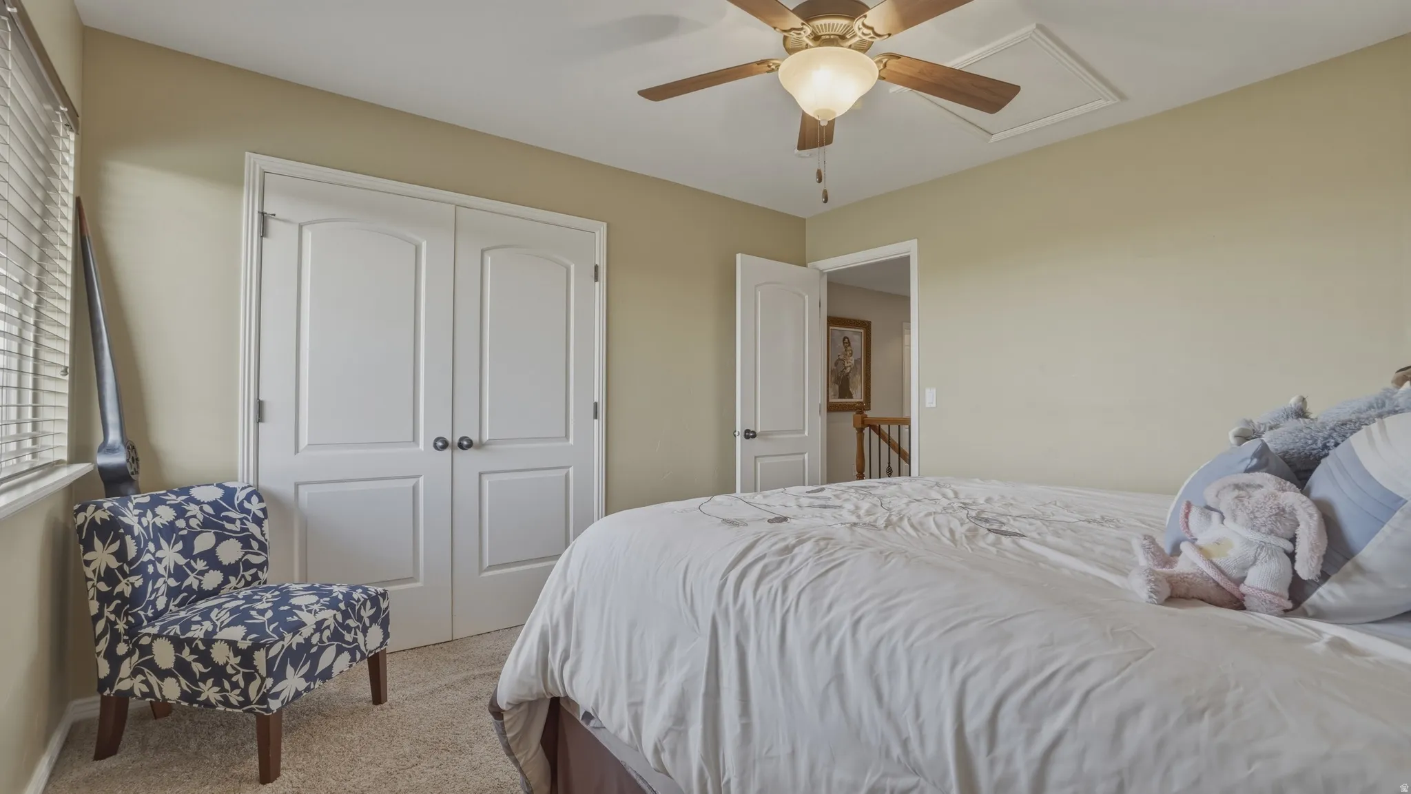 Bedroom featuring light colored carpet, a closet, and a ceiling fan