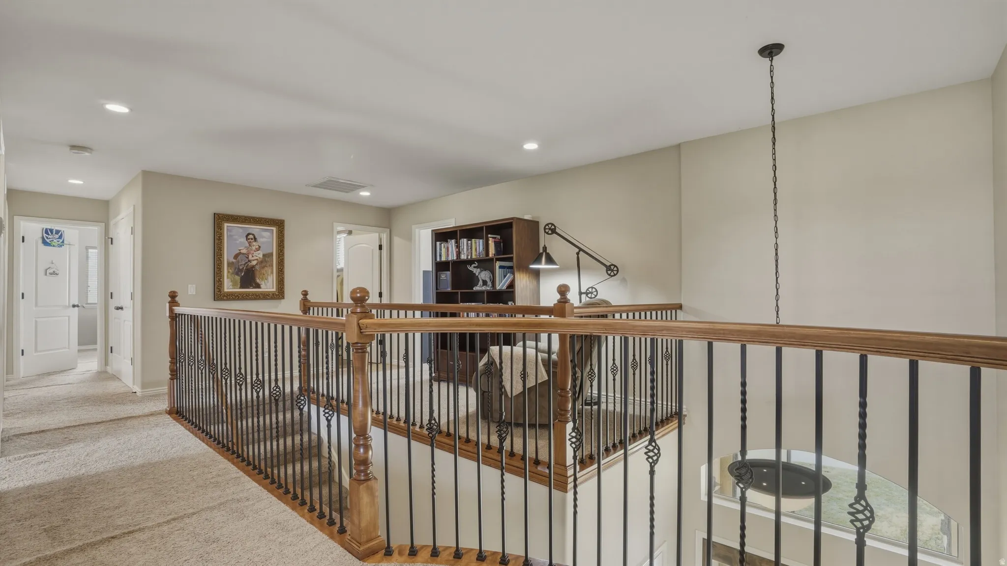 Hallway with carpet, recessed lighting, and an upstairs landing