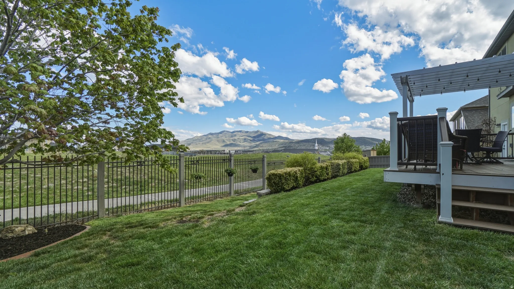 Fenced backyard with a deck with mountain view