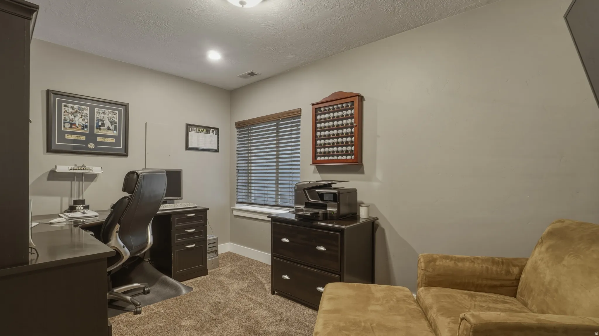 Office space featuring light colored carpet and a textured ceiling