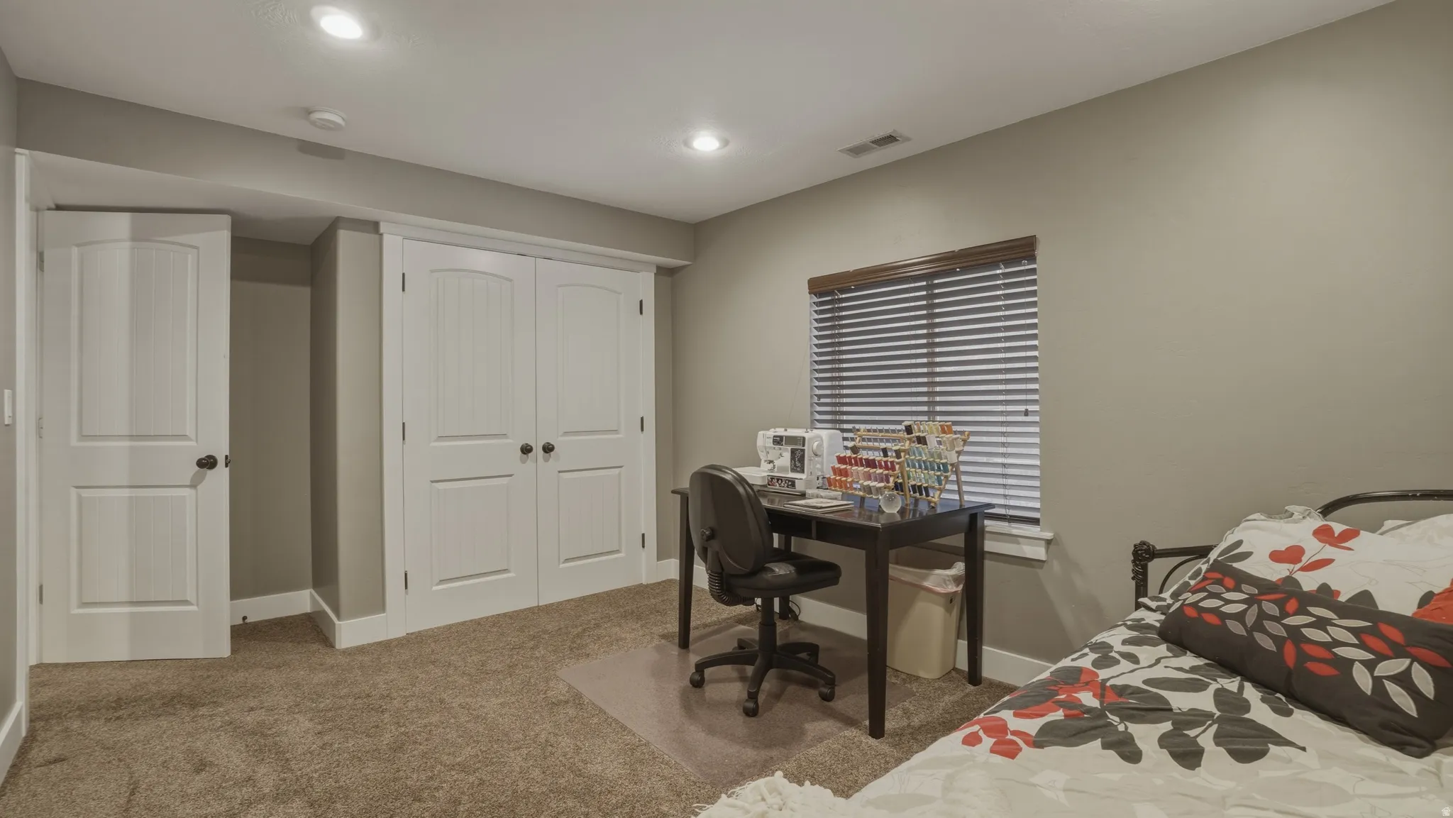 Carpeted bedroom with a closet, an office area, and recessed lighting