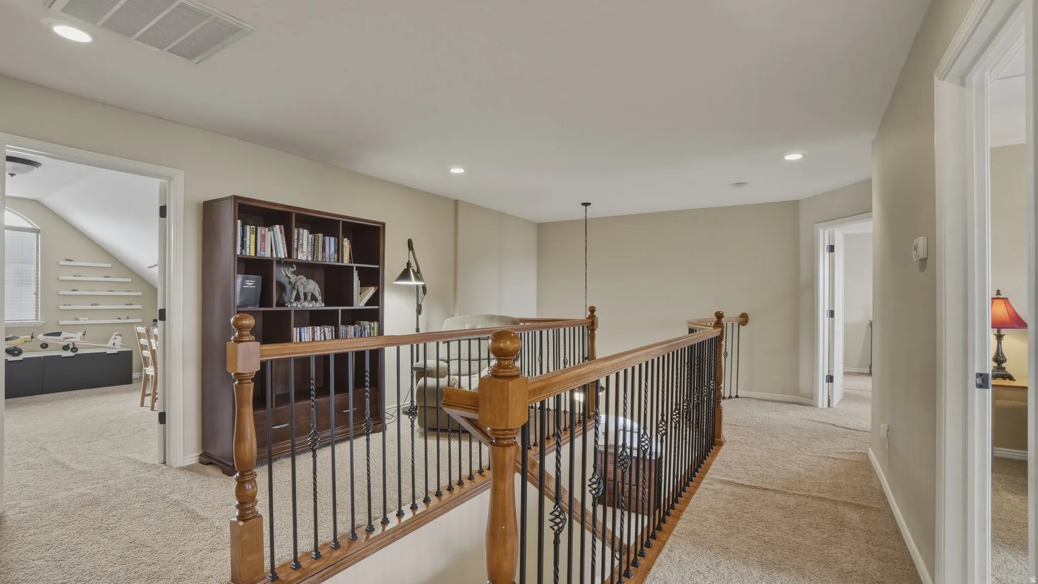 Corridor featuring an upstairs landing, recessed lighting, and light carpet
