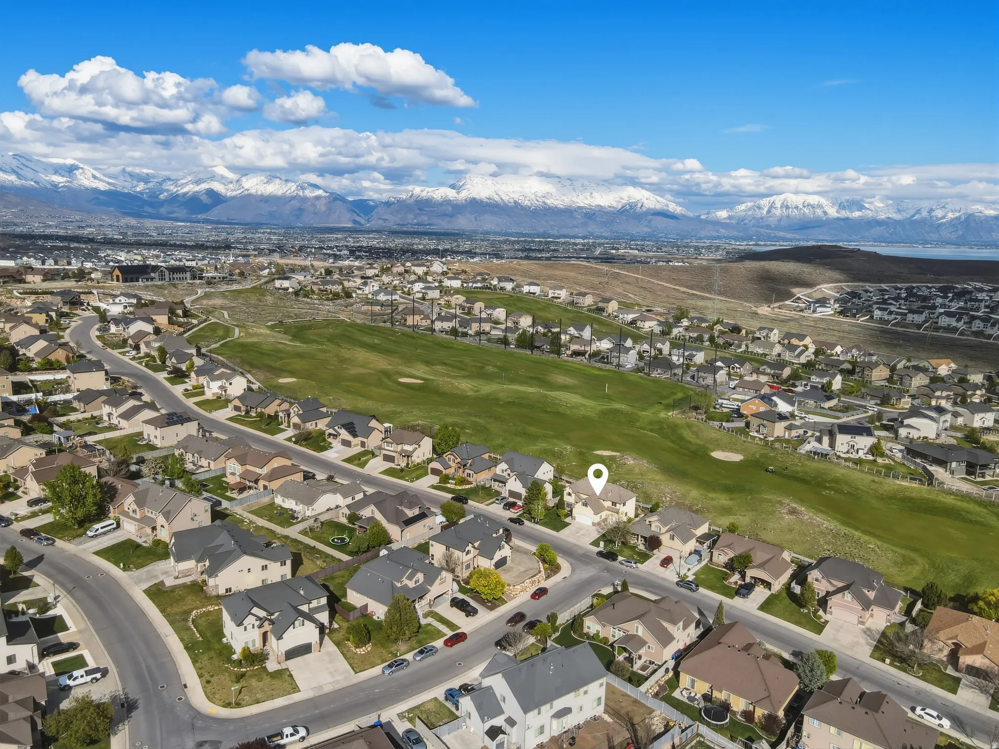 Aerial perspective of suburban area with mountains and a local golf course