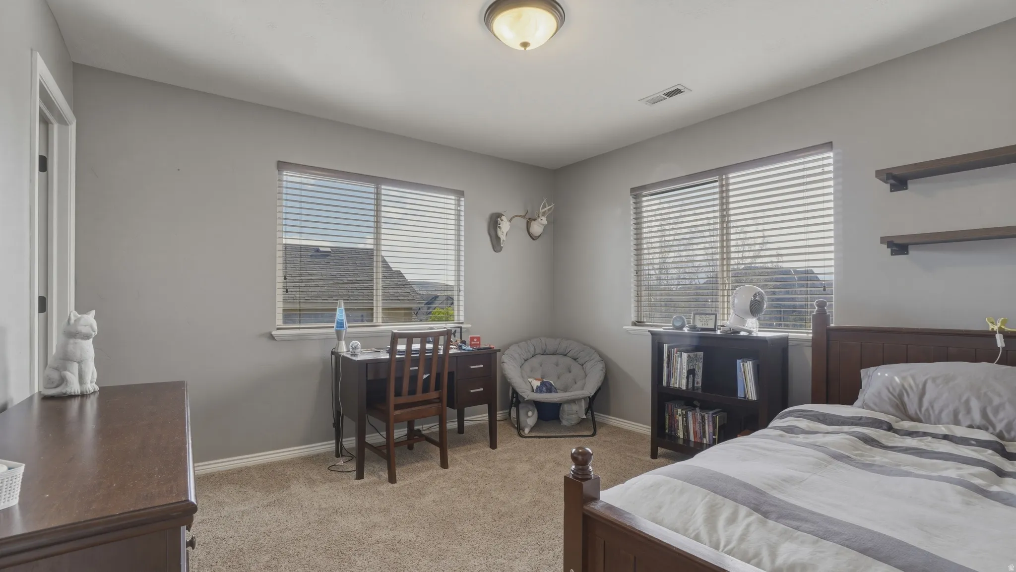Bedroom featuring light carpet and an office area