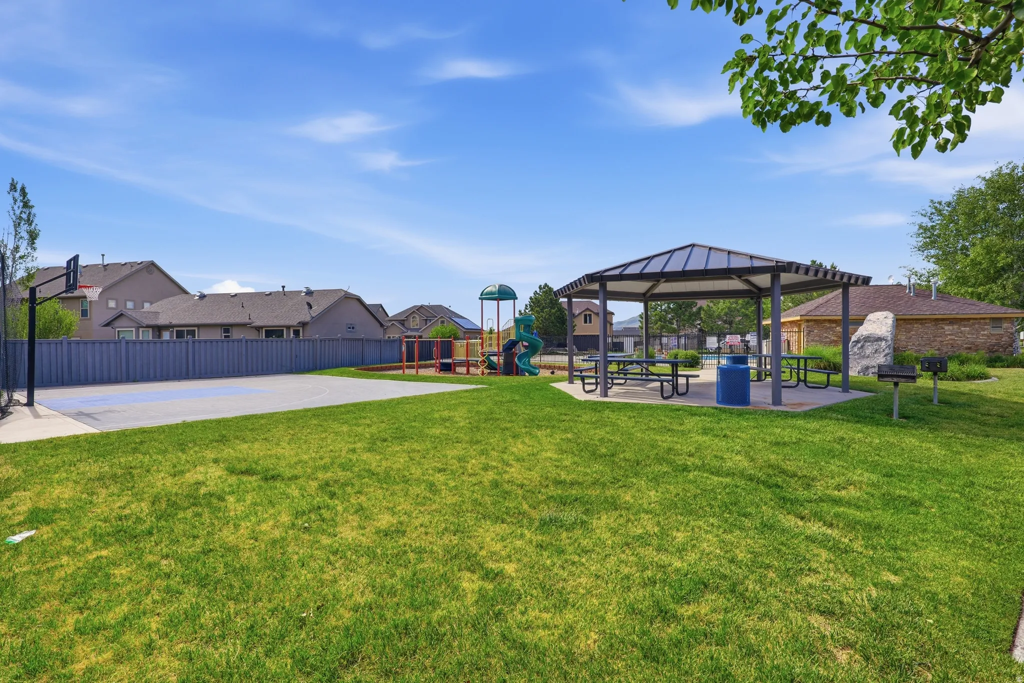 Community park featuring a basketball court, covered picnic area, and playground equipment