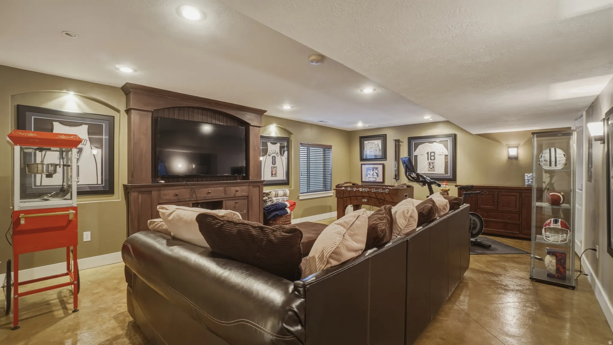 Living area with finished concrete flooring, recessed lighting, and a textured ceiling