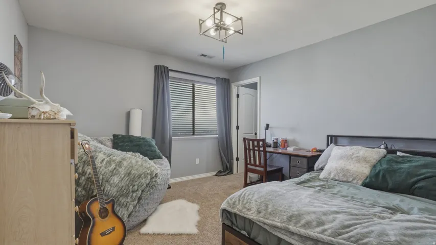 Bedroom featuring light colored carpet and baseboards