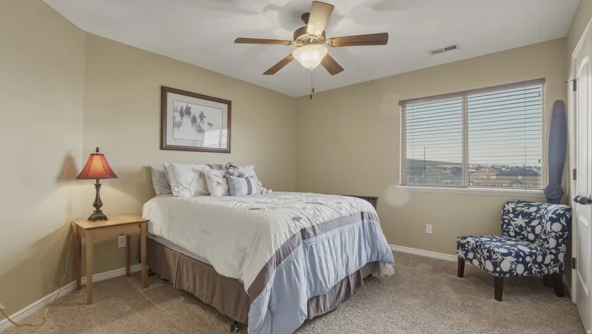 Bedroom with light carpet and ceiling fan