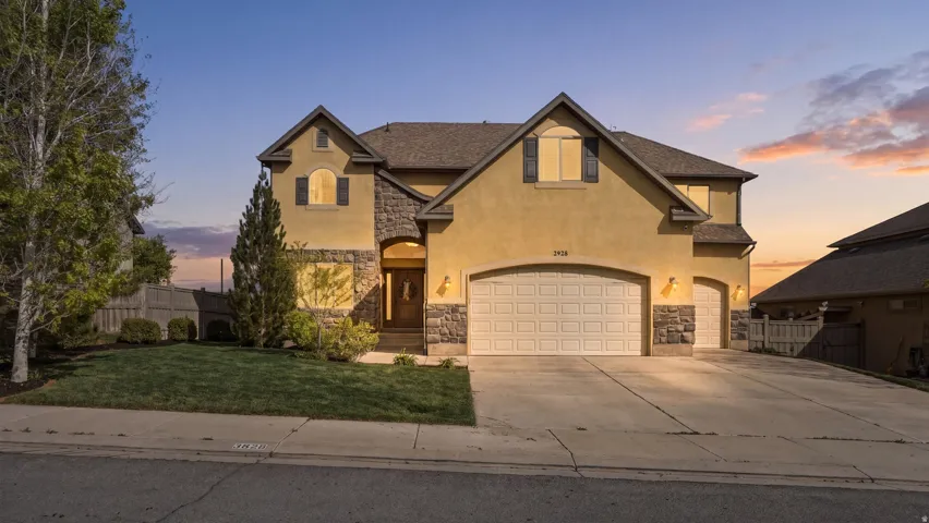 View of front of home featuring stone siding, stucco siding, concrete driveway, and a garage