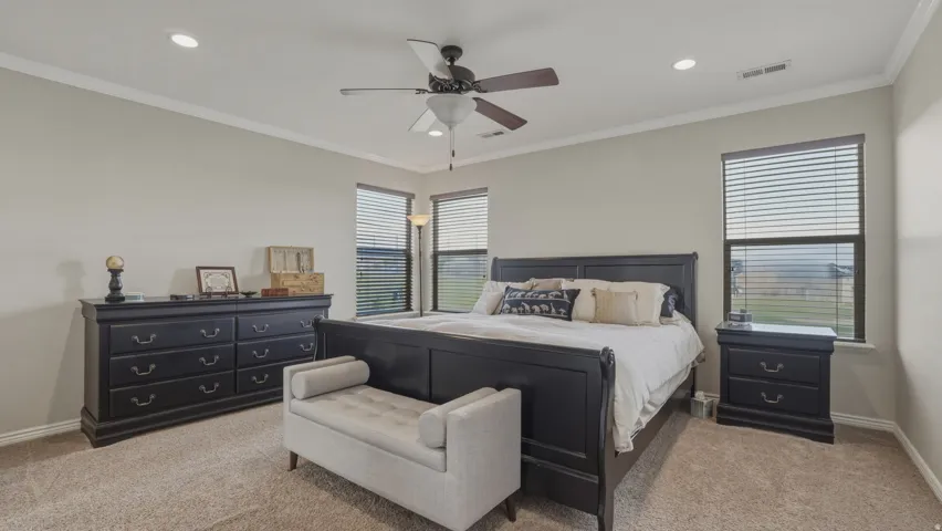 Bedroom with carpet, ornamental molding, ceiling fan, and recessed lighting