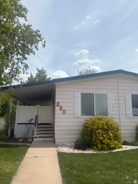 Manufactured / mobile home with a front yard and covered porch