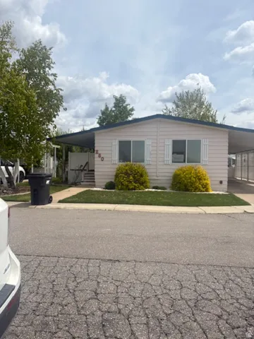 View of front of house with an attached carport and driveway