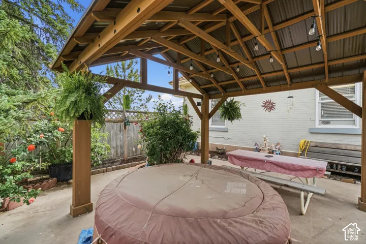 Outdoor covered patio with a wood-frame gazebo and corrugated metal roof